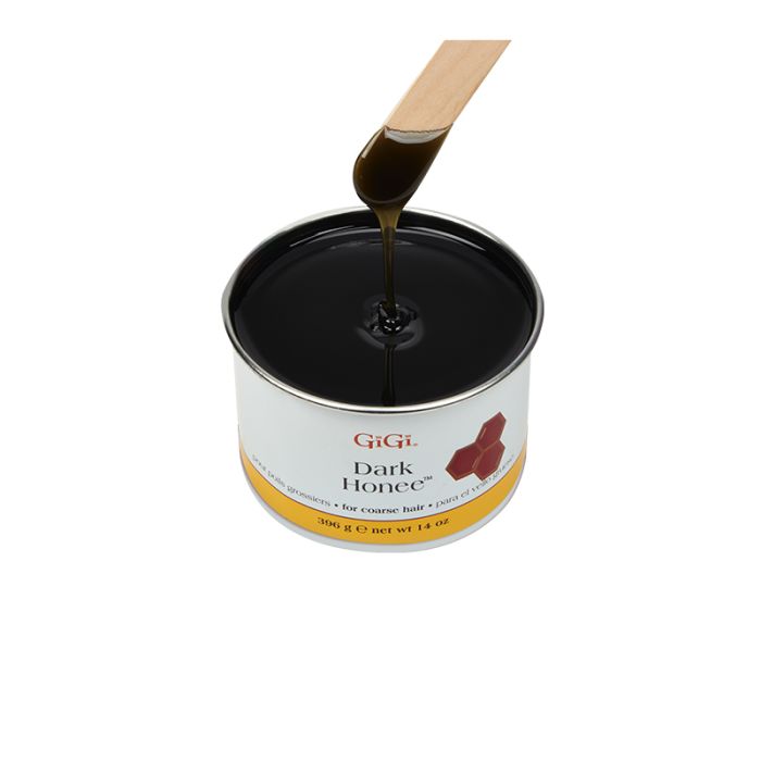 Applicator stick dipped into & drawn from a can of GiGi Dark Honee dripping with pitch dark brown wax